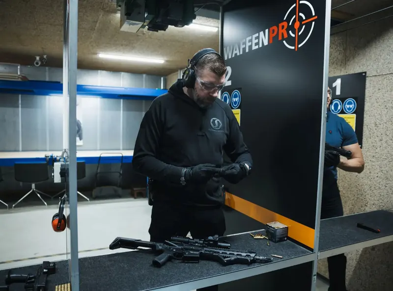 Schießleiter bereitet die Waffen auf dem Tisch vor